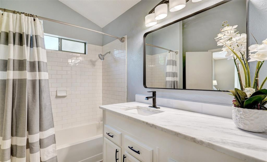 The primary bath includes a new Brazilian Marble counter and new faucet. The window above the shower/tub allows plenty of ventilation while you dress in your walk-in closet.