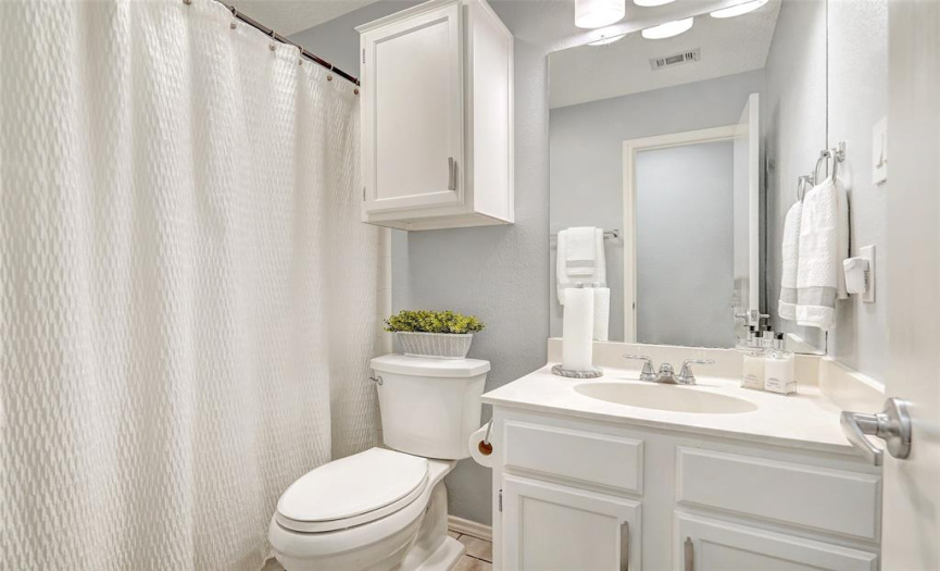 The second bath has good lighting and ample storage.