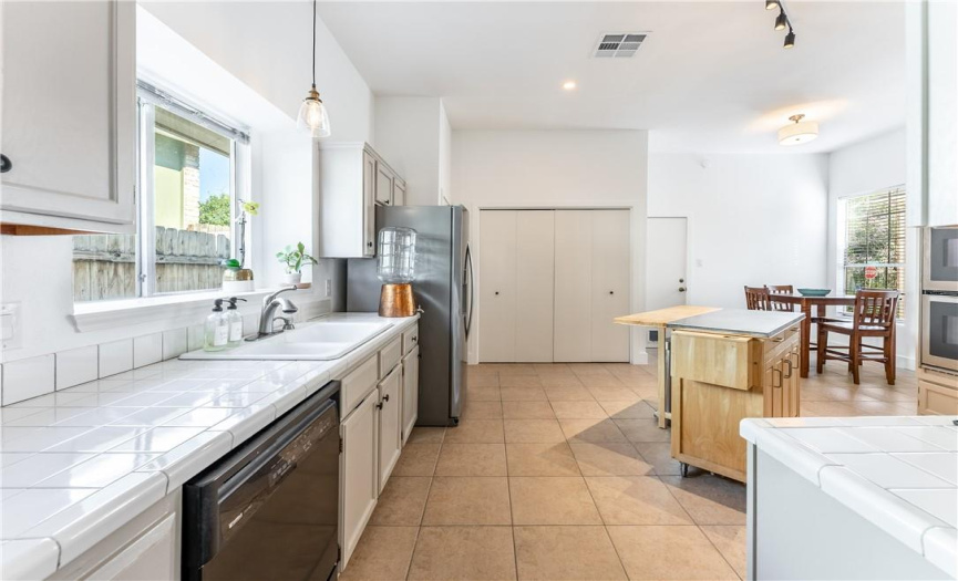 Tile counters and tile backsplash are white and bright. Refrigerator purchased in December 2020 conveys with the sale, along with the washer and dryer.