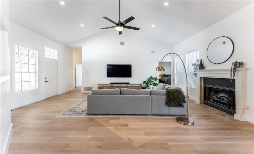 High ceilings with recessed lighting add to the spaciousness of the home. It feels like a 2500 sq ft home. The huge primary bedroom is the door on the far right and the hallway to the left leads to the secondary bedrooms and bathrooms.