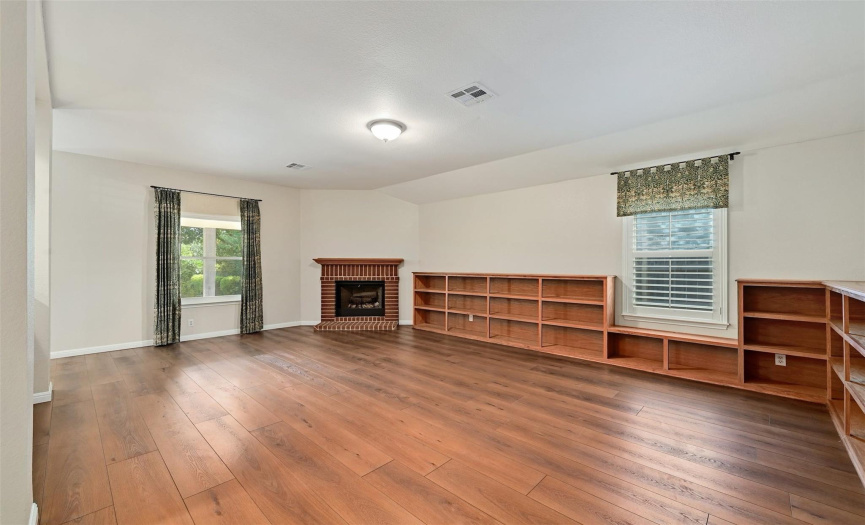 Spacious family room with custom built-ins and inviting corner fireplace