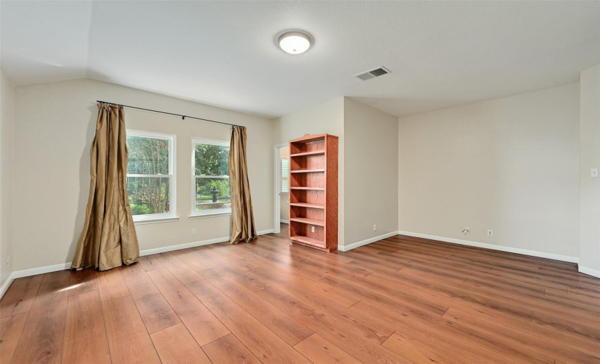 Generous sized primary suite with windows overlooking the backyard oasis and custom built-ins 