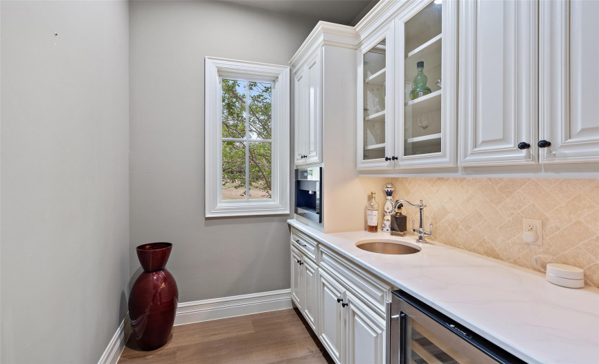 The service pantry is set between the formal dining room, wine cellar, and kitchen and has a built-in espresso maker and additional cabinet and counter space. 