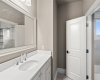 The vanity sink area leads to an adjoined bathroom shared with another secondary bedroom. 