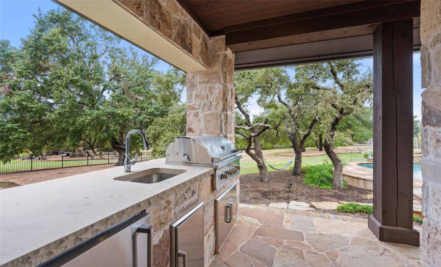 A full outdoor kitchen is conveniently located just outside a door from the kitchen. 