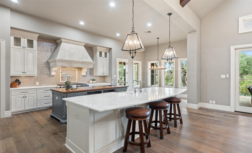 The kitchen was designed with the home chef in mind with a Wolf six burner gas stove with griddle and double oven and Carrara marble countertops. 