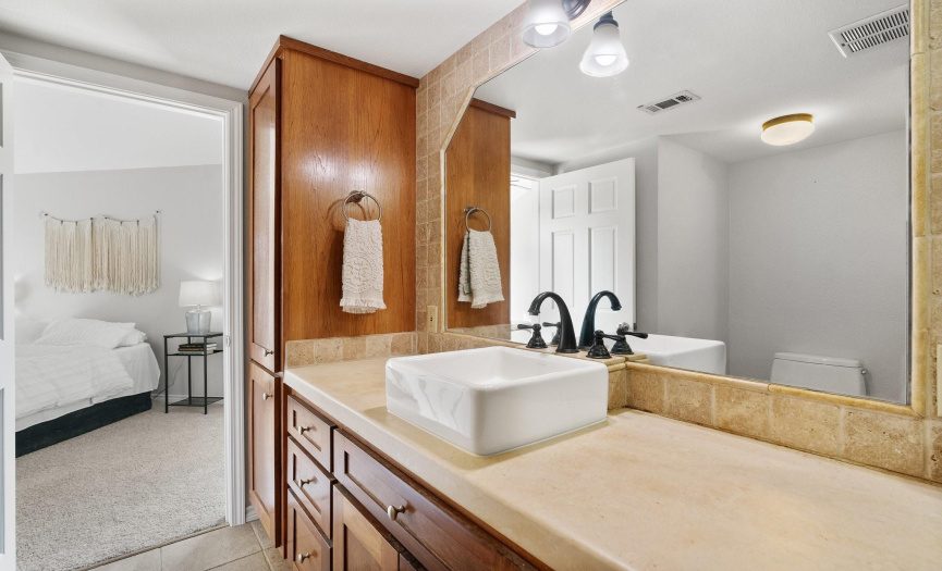 The primary bathroom features custom cabinets, concrete counters and a large shower.