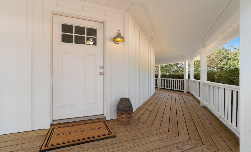 The front door is surrounded by the covered front porch that wraps around most of the home.