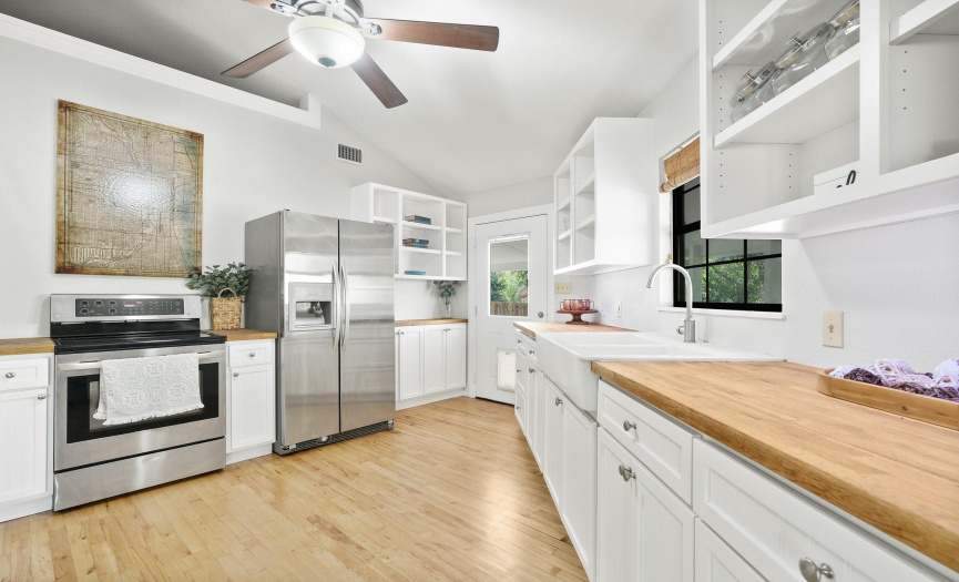 The kitchen features custom made cabinets with butcher block counters and a farmhouse sink.