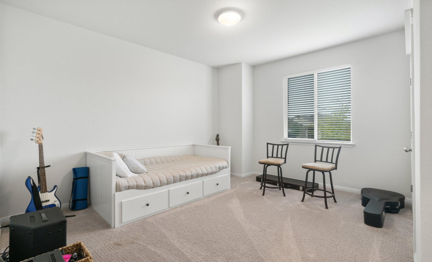 A well-appointed second bedroom provides comfort and style for guests or family members.