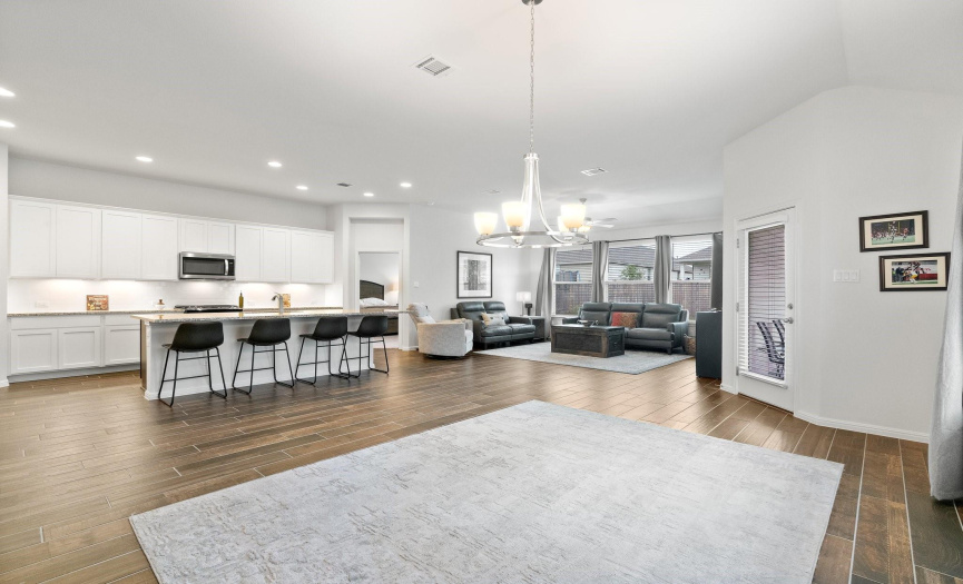 As you explore this stunning abode, you'll be greeted by 10' ceilings, elegant wood-look tile flooring, & an abundance of natural light that bathes the space in a warm, welcoming glow.