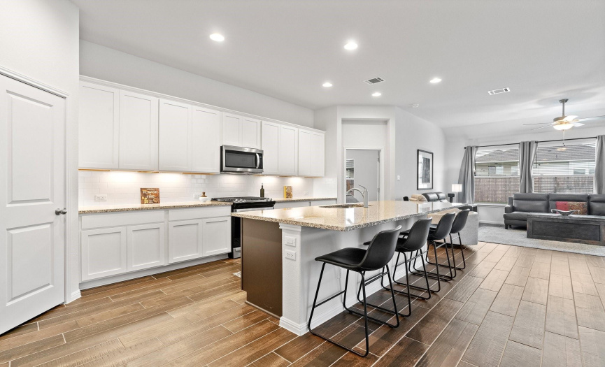 The kitchen, the heart of the home, boasts a large center island, granite countertops, and high-quality stainless-steel appliances.
