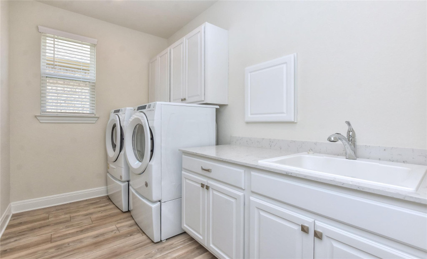 Laundry Room has sink plus extra cabinets.