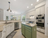 Island kitchen with granite countertops & white tile backsplash.