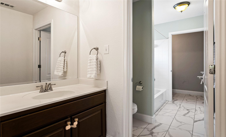 The Jack-and-Jill bathroom offers dual sinks and a shower/tub combination. 