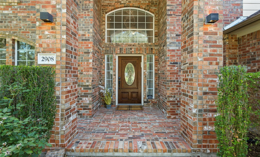 Grand brick front porch with large window to let in tons of natural light.