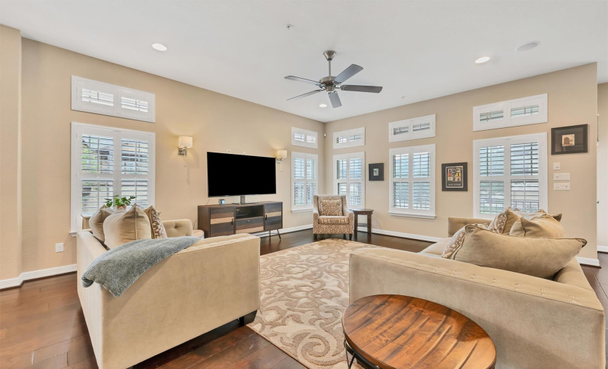 High ceilings, many windows, plantation shutters, gorgeous hickory wood floors, and an open-concept living area make this space feel bright and airy. 