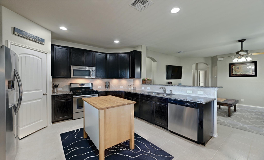 The kitchen offers plenty of space for a center prep island plus plentiful cabinetry storage and a pantry. 