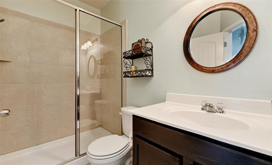 The full secondary bathroom provides a walk-in shower and beautiful tile backsplash & floors. 