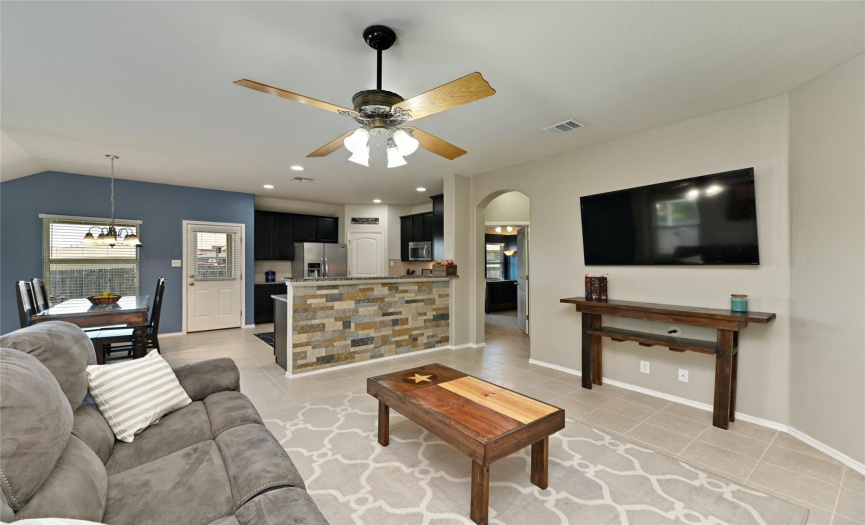 The main living area features tall ceilings, recessed lighting, and refreshing tile floors. 