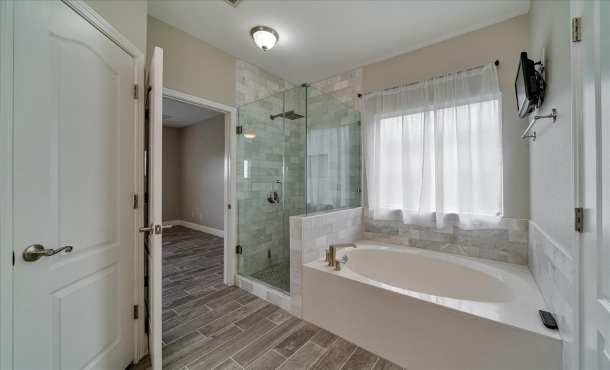 Primary Bath, walk in oversized shower, soaking tub with flat screen tv * Bathrooms have all been UPDATED in this home.