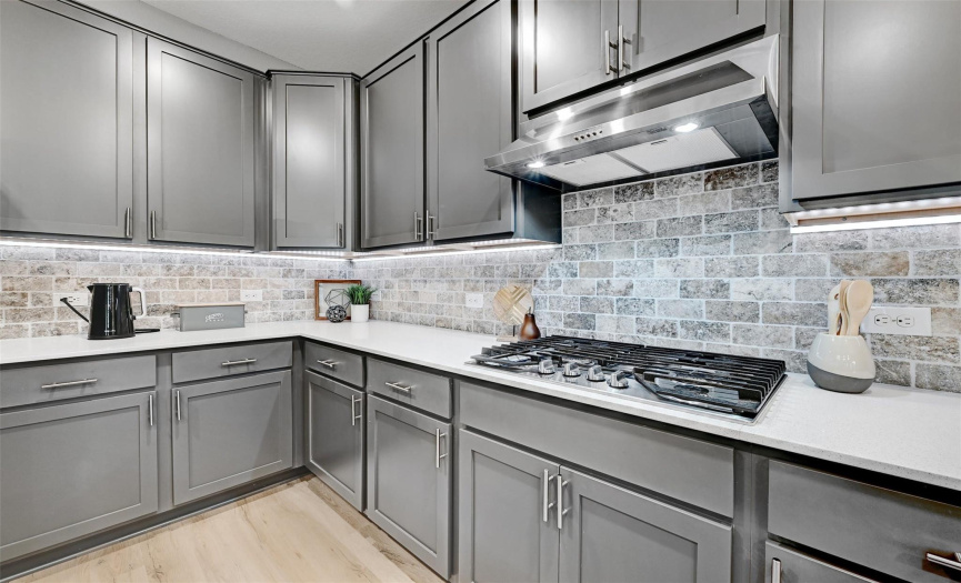 The under-cabinet led lighting adds a beautiful glow to all of the work areas, highlighting the attractive backsplash!