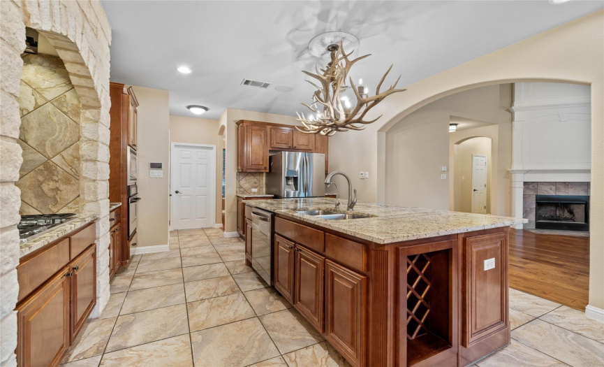 This gourmet kitchen boasts a large island, gleaming stainless steel appliances, a stunning stone grotto, and impeccably crafted custom cabinets, creating a culinary haven for any aspiring chef.