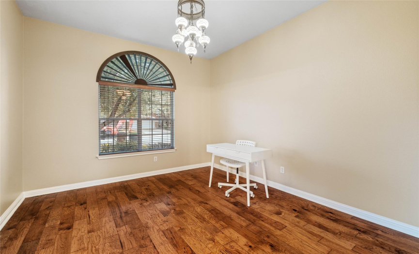 Study with French doors, hardwood flooring and chandelier.