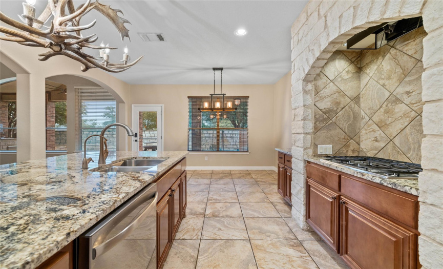 Beautiful granite counters and oversized tile adorn this spectacular kitchen.