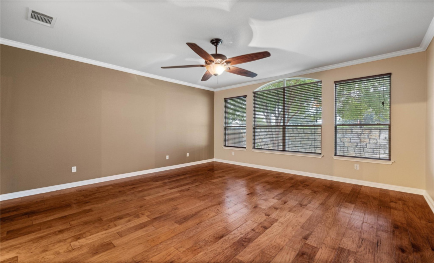 The tranquil master suite boasts of hardwood flooring, crown molding, designer paint and ceiling fan.