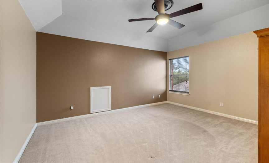 Rear bedroom with designer paint, walk-in closet and ceiling fan.