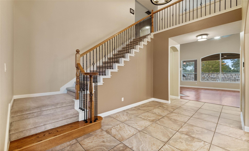 This two story entry features a stunning staircase with wrought iron balusters, stained starter step and voluted rail.  