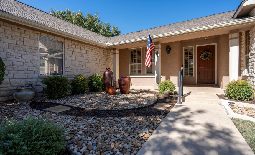 Gorgeous immaculate landscaping and a covered front porch welcome you to your new home.