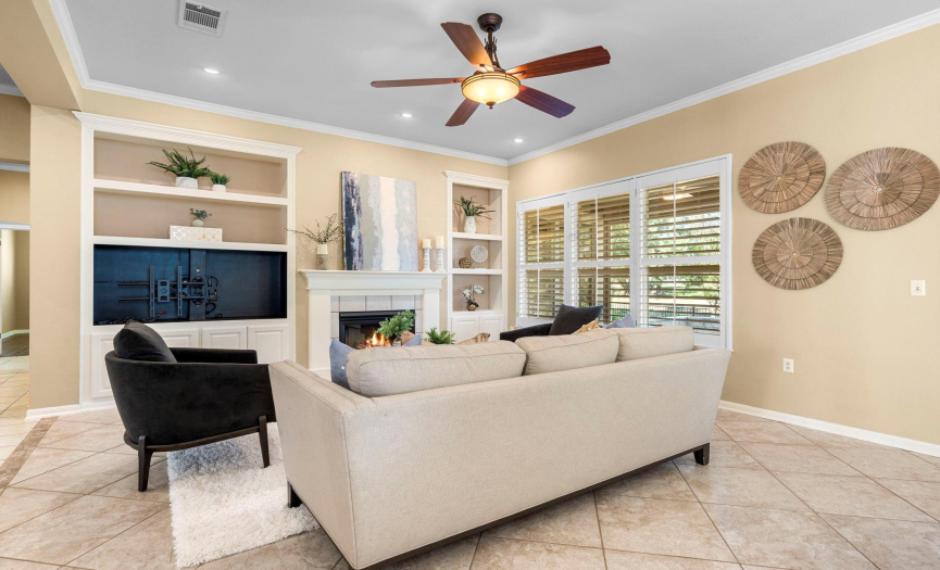 A gas fireplace, plantation shutters, crown molding and built-ins ready for your television and keepsakes await you in the open living area.