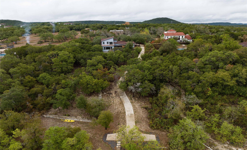 Overhead view of the property, house, paved road/cart path from house to boat dock, grassy area near lake