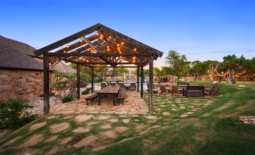 The expansive pergola frames a custom wooden table that can easily seat 18 people.