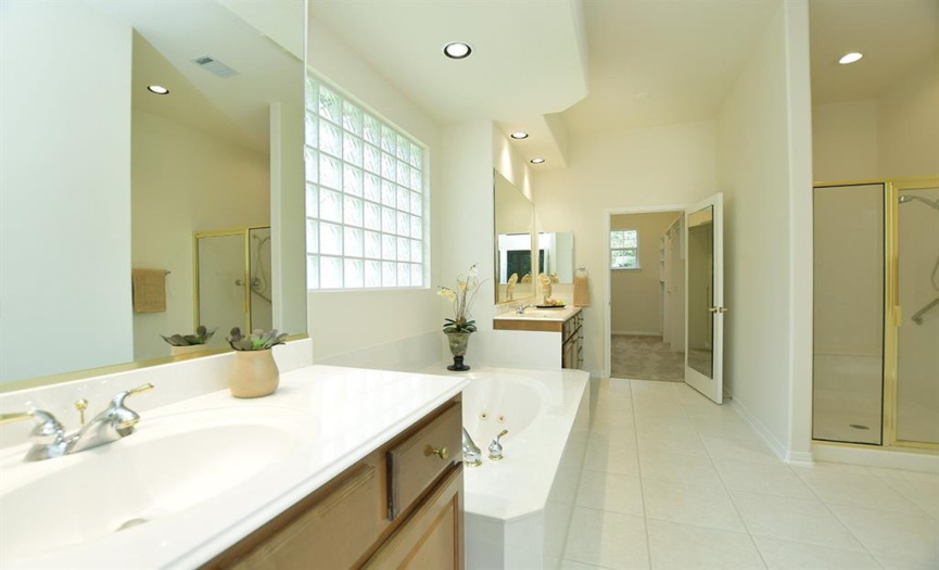 The en-suite primary bath features separate dual vanities, jetted tub, standalone shower, separate water closet and large walk-in clothes closet.
