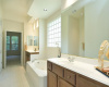 A jetted tub gently divides the dual vanities while a large glass block window sheds natural light.