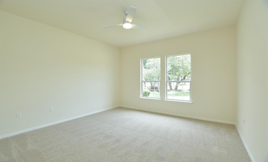 With it's 10-ft ceilings, a generously sized guest bedroom looks to the front of the house and features new carpet and low profile ceiling fan.