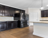 Kitchen features granite countertops and the refrigerator comes with the home. 