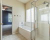Glass block window over the soaker tub lights the en suite primary bath with separate soaking tub & walk in shower