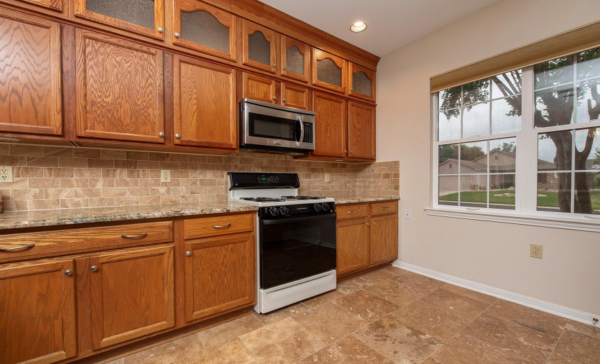 5- The extra cabinets above the granite countertop improves storage.