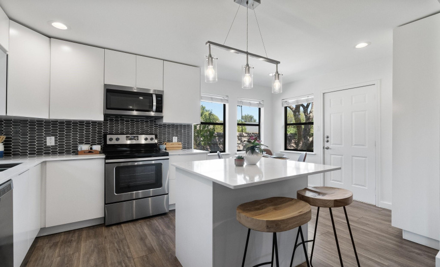 Updated kitchen with quartzcountertops, modern backsplash& center island.