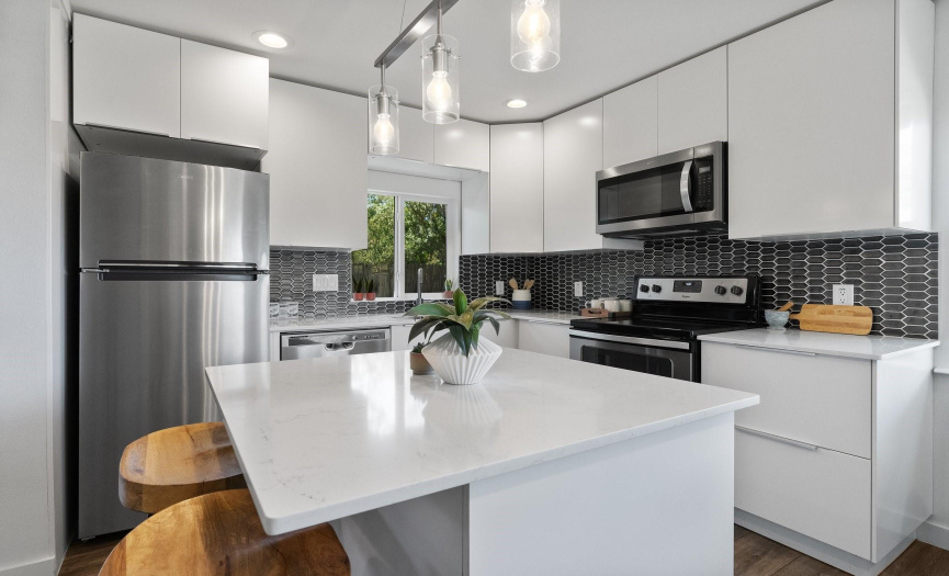 Updated kitchen with quartzcountertops, modern backsplash& center island.