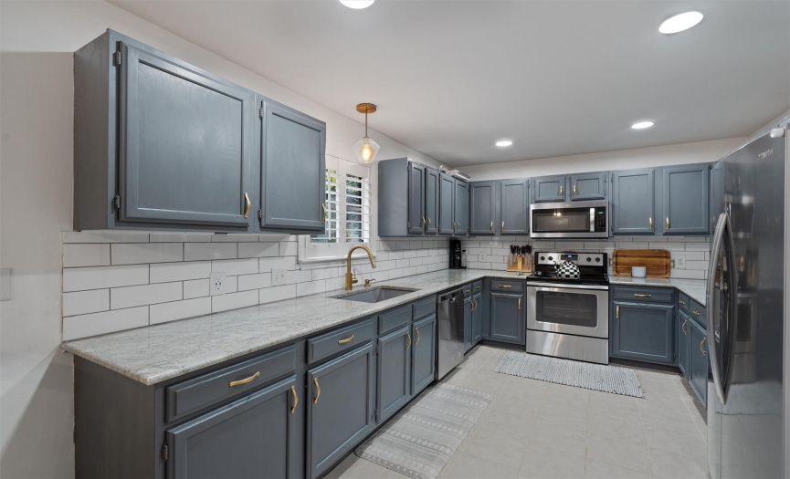The spacious kitchen provides plentiful counter space and cabinetry storage with stylish updated hardware and freshly pained cabinetry. 