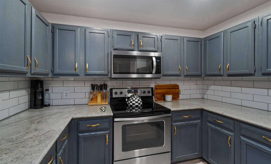 Sleek stainless steel appliances include this electric range & microwave plus a dishwasher. 