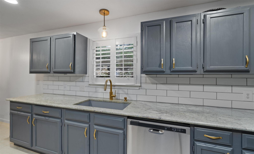 Classic subway tile backsplash ties the modern upgrades together with the granite countertops, brass handles, and plantation shutters. 