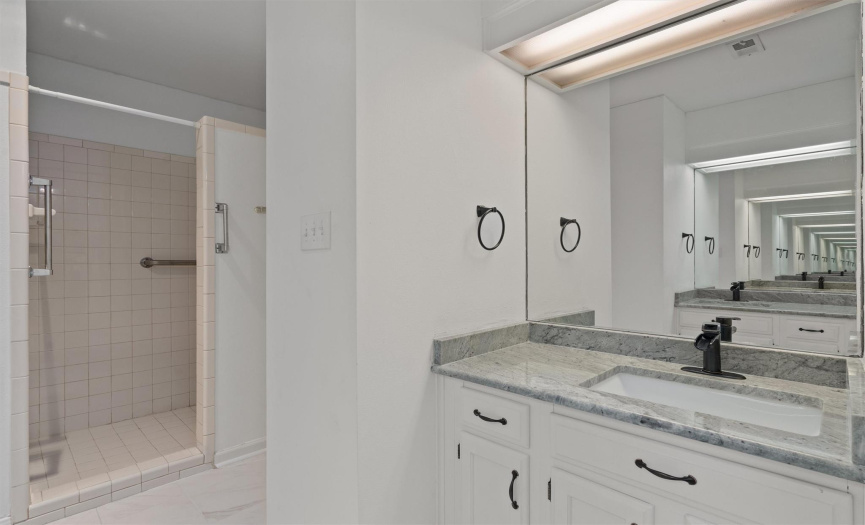 Stylish modern renovations in this private ensuite bathroom include updated granite countertops and gorgeous designer tile floors. 