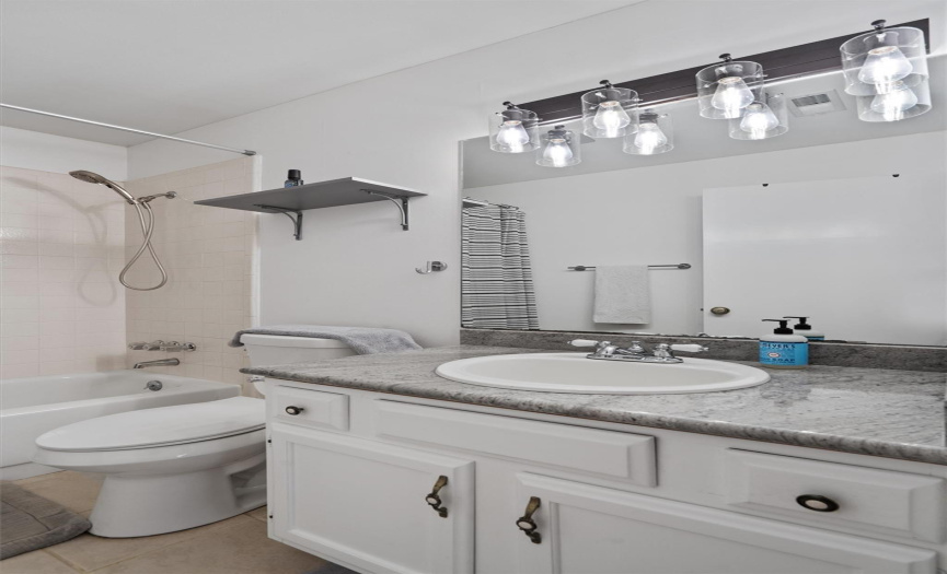 This bathroom also offers an updated commode and contemporary light fixtures. 