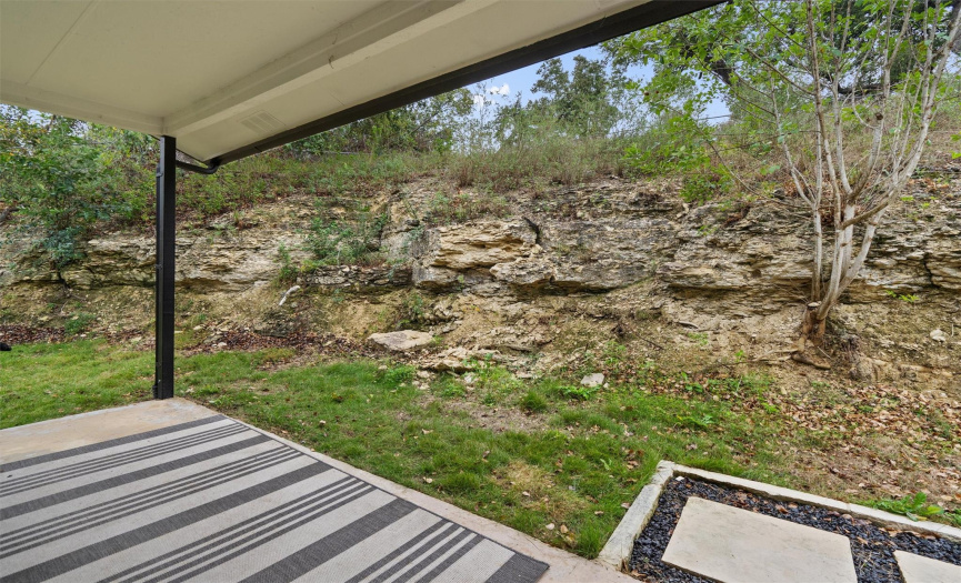 A stunning natural rock wall provides a picturesque natural backdrop for your outdoor living space.